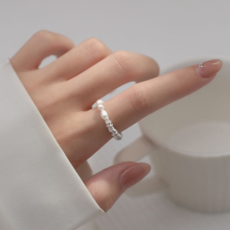 BoxUnboxed sterling silver coiled ring with two small freshwater pearls. Minimalist, modern design.