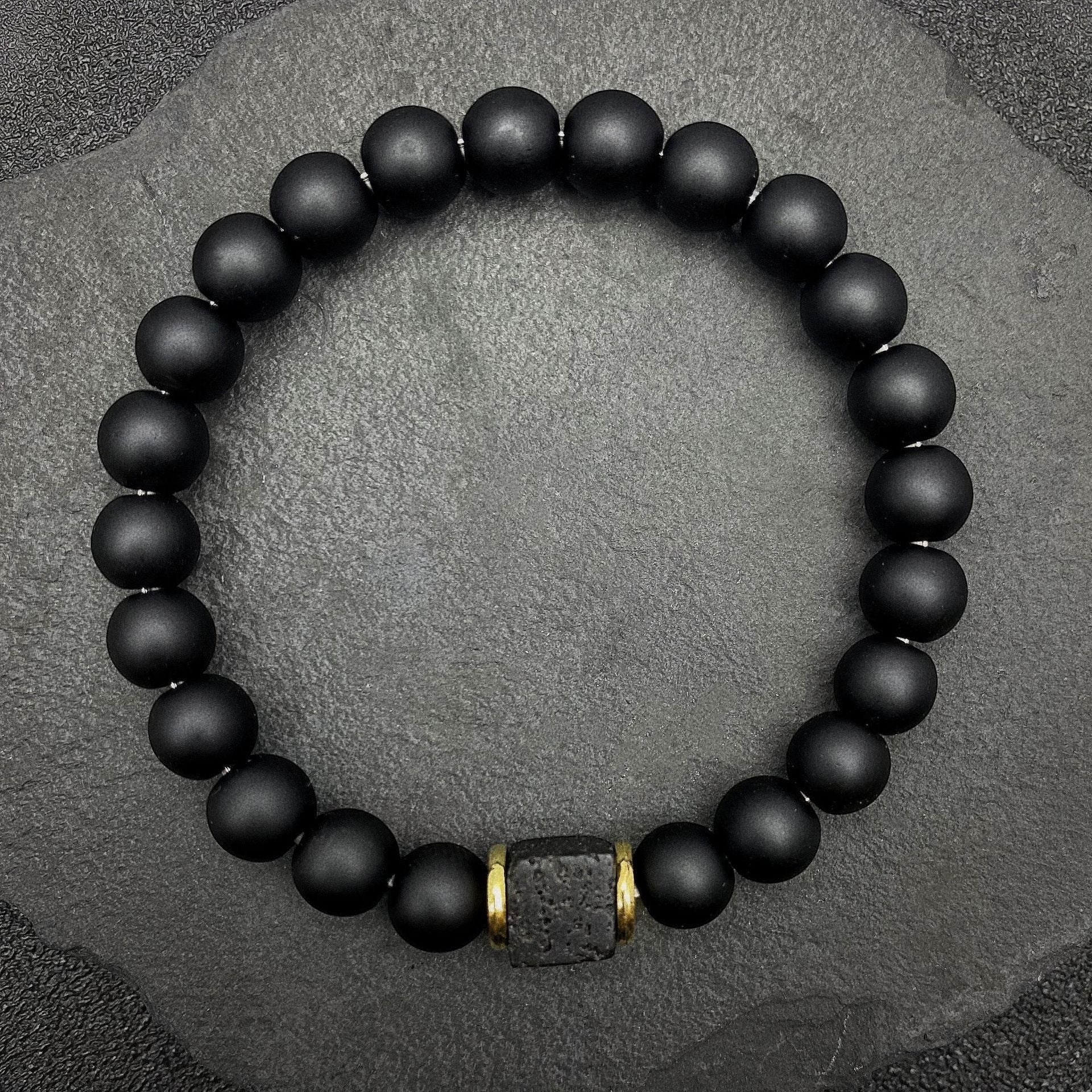 BoxUnboxed Obsidian & Volcanic Stone Stack Bracelet with matte black beads and a single textured lava stone accent.