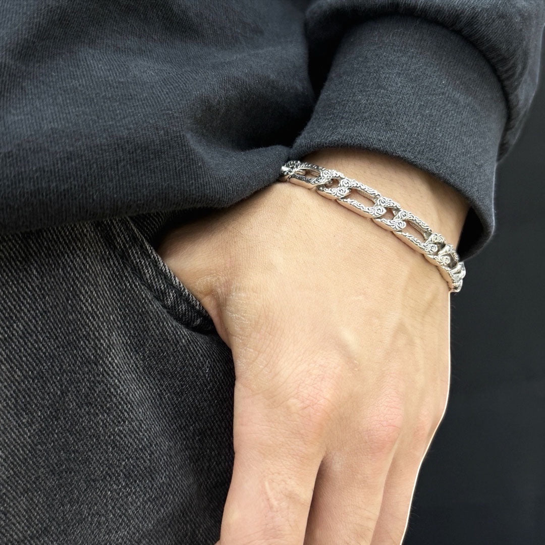BoxUnboxed Sovereign Imperial Rattan Figaro Chain bracelet in solid 925 silver with intricate vine pattern engraving and oxidized finish.
